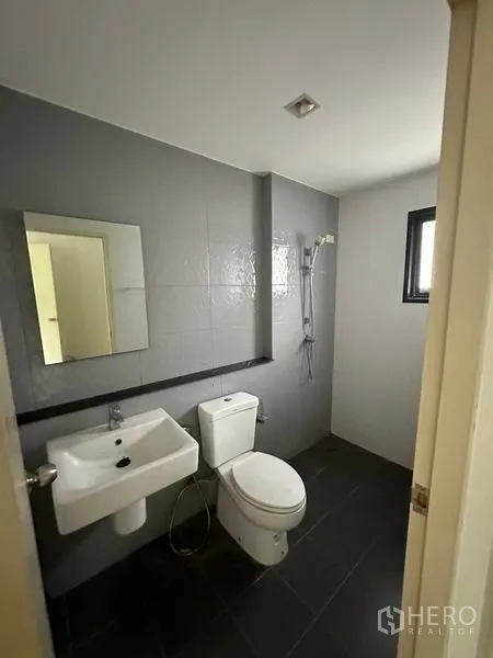 บ้าน ขายในBang Khen, Bangkok - ห้องน้ำโทนเทา‑ขาวพร้อมฝักบัวและช่องแสง.