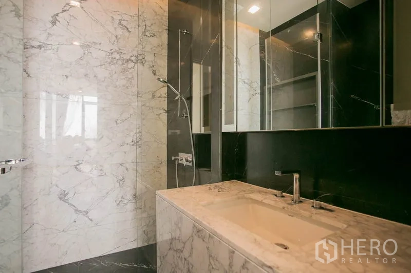 公寓 出租或出售在Watthana, Bangkok - 大理石台面与下嵌式洗手盆，镜柜及玻璃淋浴区。