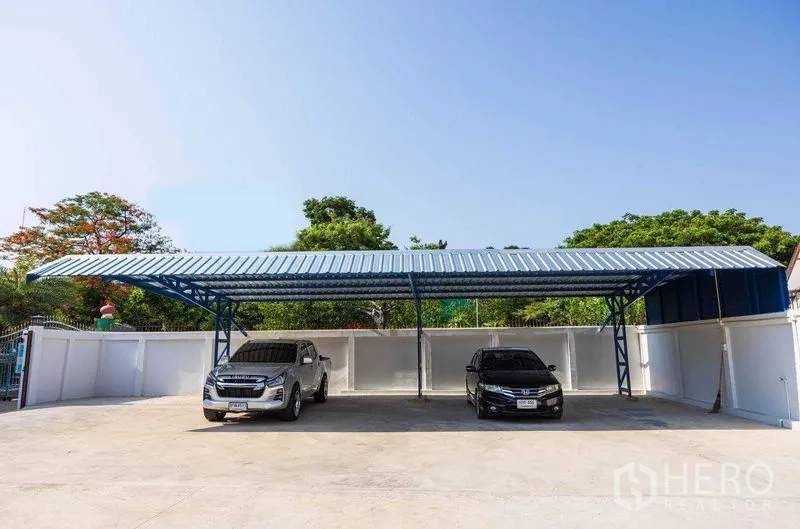 Home Office for rent in Watthana, Bangkok - Covered parking with blue steel roof and two cars within a gated home office compound in Watthana, Bangkok near BTS Thonglor.