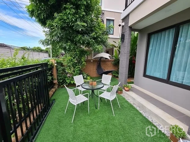 Detached House for sale in Suan Luang, Bangkok - Private side garden with artificial turf, outdoor table and chairs, and lush plants.