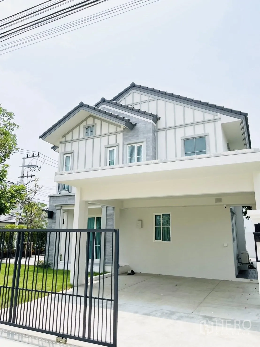 Detached House for rent in Bang Phli, Samut Prakan - Front facade with gated driveway and covered carport.