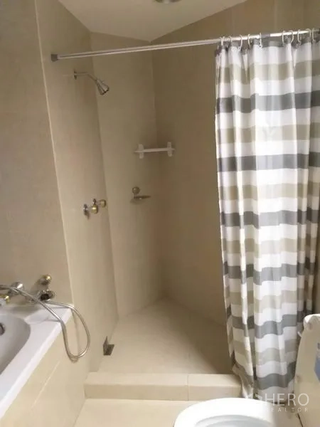 คอนโด ให้เช่าในBang Kho Laem, Bangkok - ห้องน้ำมีอ่างอาบน้ำ โซนอาบน้ำแยก และม่านลายทางโทนอบอุ่น