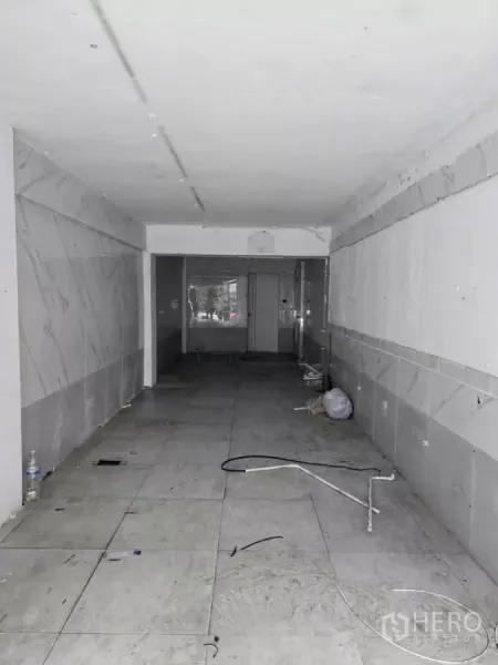 零售空间 出租在Watthana, Bangkok - 店内狭长开放式空间，地砖与白墙，线路外露，待装修。