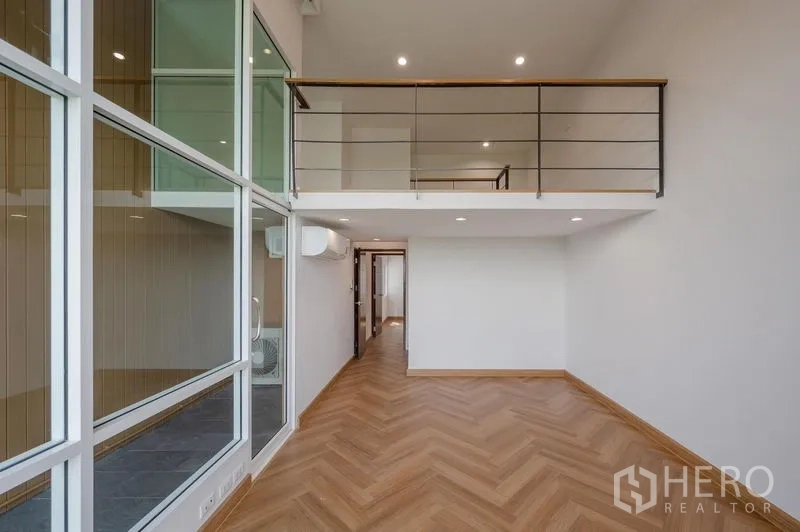 ทาวน์เฮาส์ ขายในLat Phrao, Bangkok - โถงเพดานสูงผนังกระจกเต็มบานพร้อมชั้นลอยและราวเหล็ก