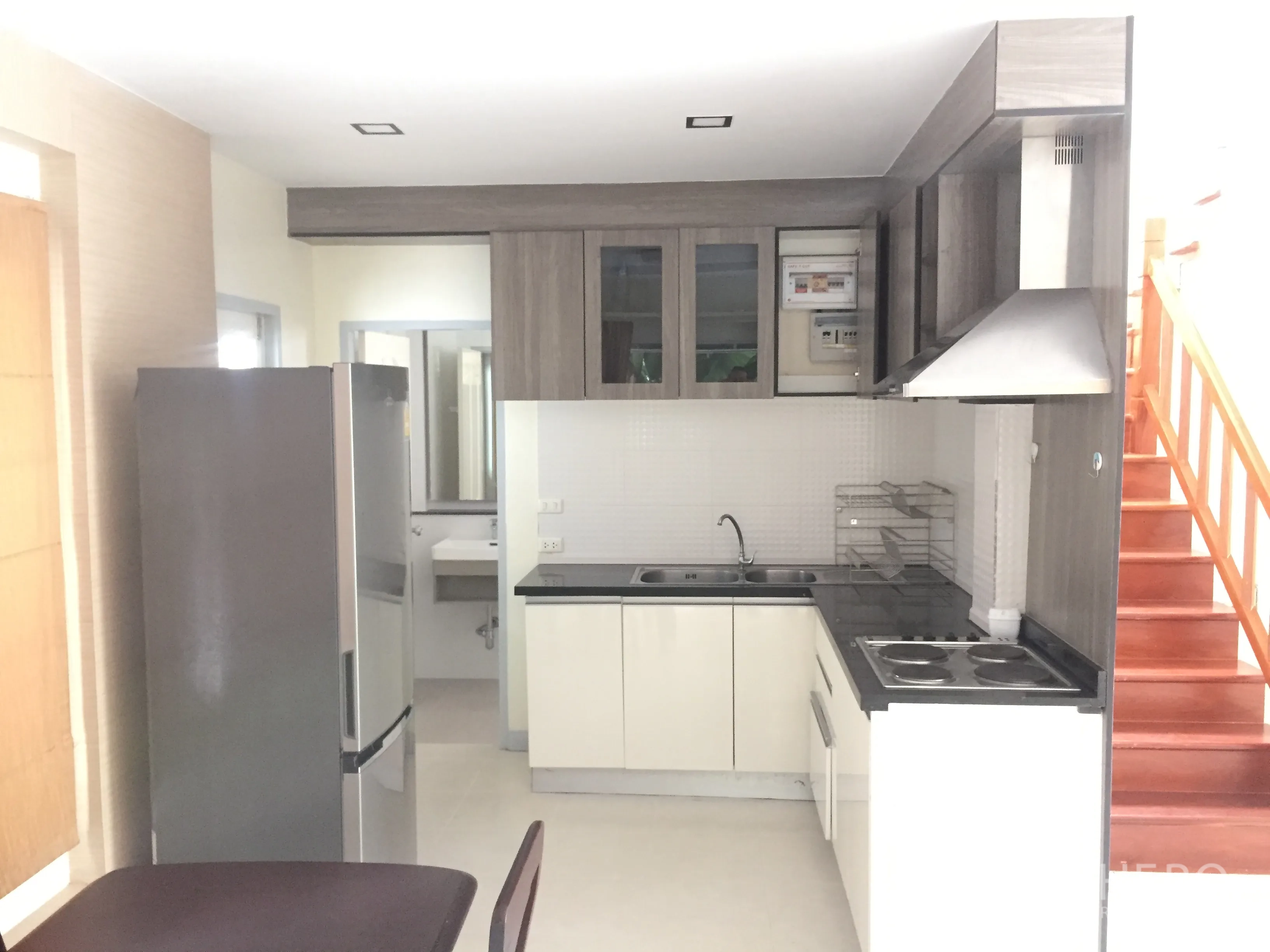 บ้าน ขายในLat Krabang, Bangkok - ครัวยุโรปขนาดกะทัดรัด พร้อมตู้เก็บของ เตา เครื่องดูดควัน และตู้เย็น ข้างบันได