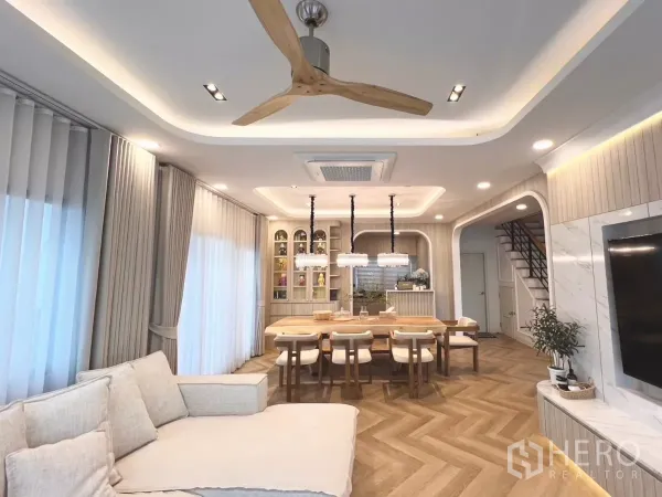 Detached House for rent in Bang Phli, Samut Prakan - Open-plan living and dining room with cassette air conditioner, ceiling fan and herringbone wood floors.