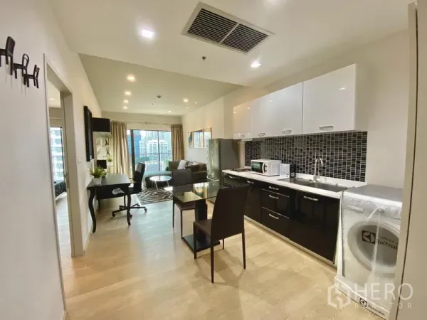 公寓 出租在Bangkok - 开放式厨房，马赛克挡板、餐桌与洗衣区，通向客厅。