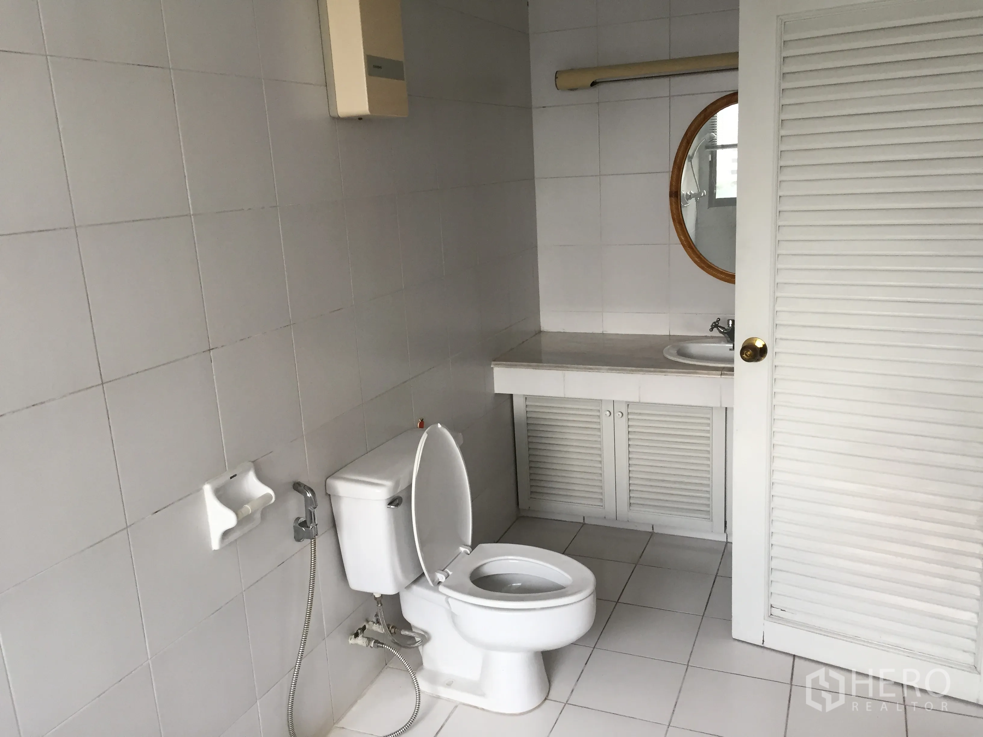 คอนโด ให้เช่าในWatthana, Bangkok - ห้องน้ำปูกระเบื้องสีขาวพร้อมโถสุขภัณฑ์และอ่างล้างหน้ากระจกทรงกลม