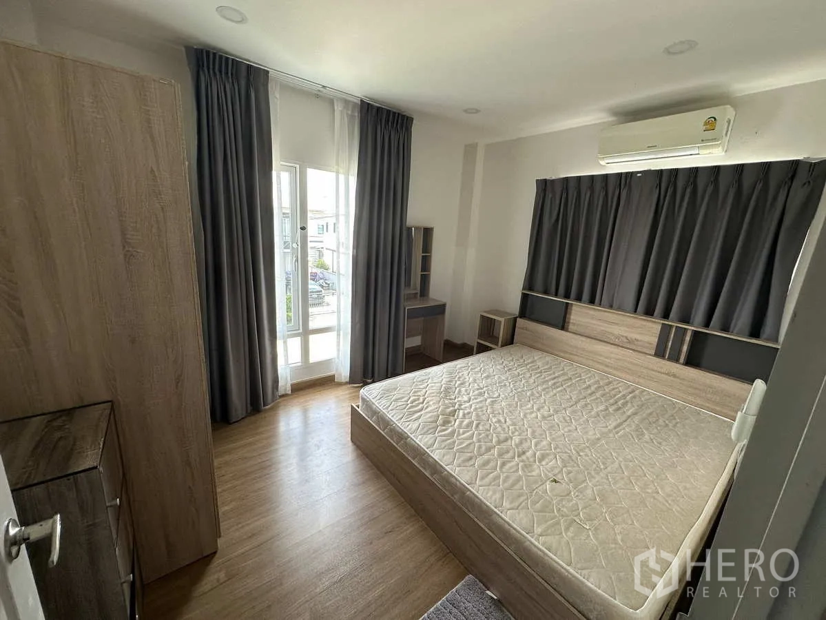 บ้าน ให้เช่าในKhlong Luang, Pathum Thani - ห้องนอนมีเฟอร์นิเจอร์ เตียง ตู้ และทางออกสู่ระเบียง