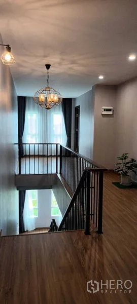 联排别墅 出租或出售在Saphan Sung, Bangkok - 楼梯平台配吊灯与金属栏杆，现代风格。