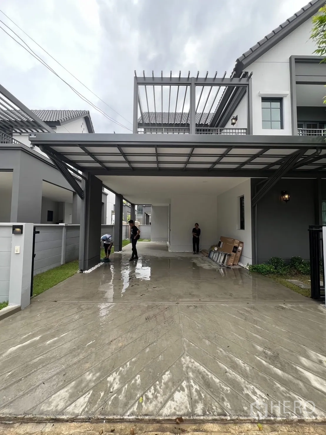 Detached House for rent in Bang Phli, Samut Prakan - Wide covered carport and long driveway beneath a metal pergola at the house entrance.