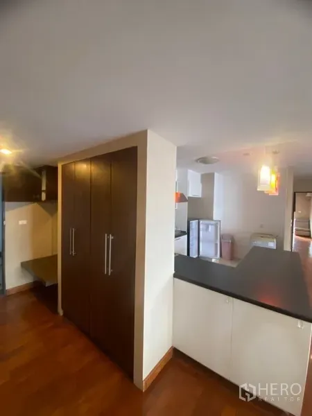 公寓 出租或出售在Watthana, Bangkok - 入口走廊带高柜，旁为连接厨房的黑色台面吧台