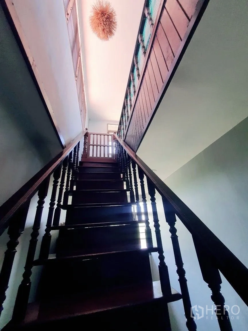 货栈 出租在Lam Luk Ka, Pathum Thani - 通往二层的实木楼梯，配吊灯