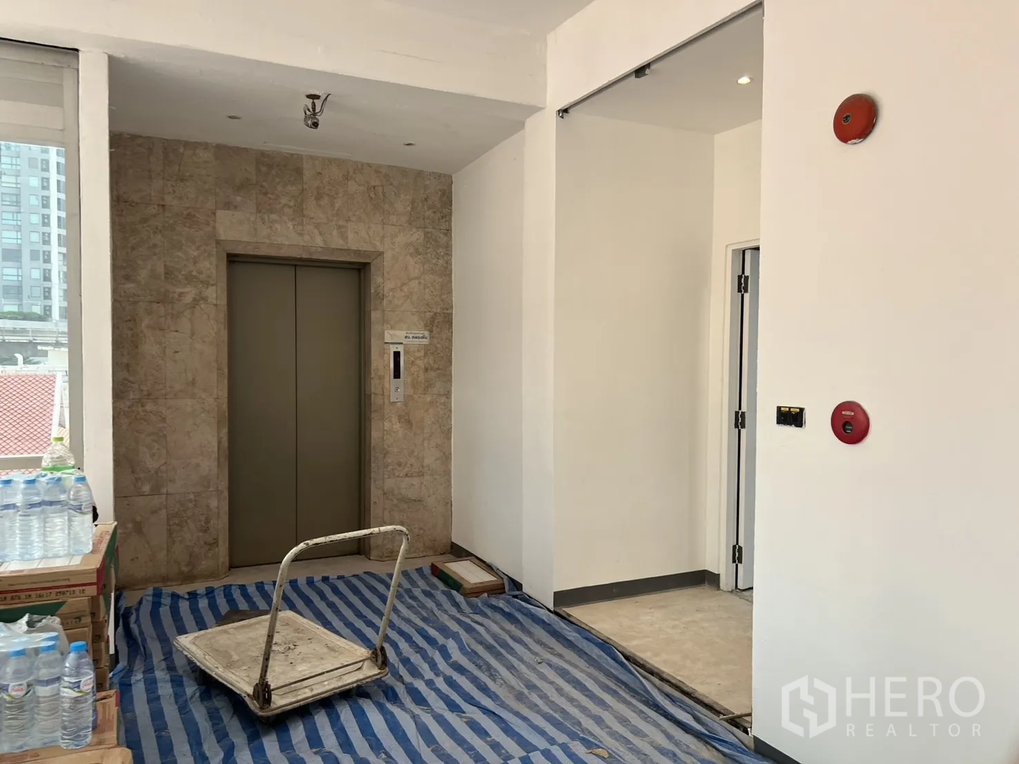 Office Space for rent in Watthana, Bangkok - Lift lobby with marble-clad elevator entrance and fire safety fixtures.