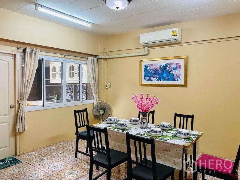 ทาวน์เฮาส์ ให้เช่าหรือขายในPrawet, Bangkok - ห้องทานอาหารจัดโต๊ะสำหรับหกที่ ถัดจากหน้าต่างที่มองไปครัว และมีแอร์