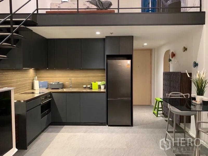 公寓 出租在Bang Rak, Bangkok - 现代L形厨房，内嵌烤箱和冰箱。