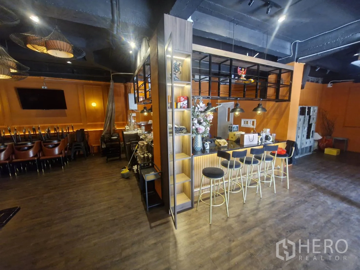 Shophouse for rent in Pathum Wan, Bangkok - Warm-toned bar counter with open shelving and pendant lights in a shophouse interior.