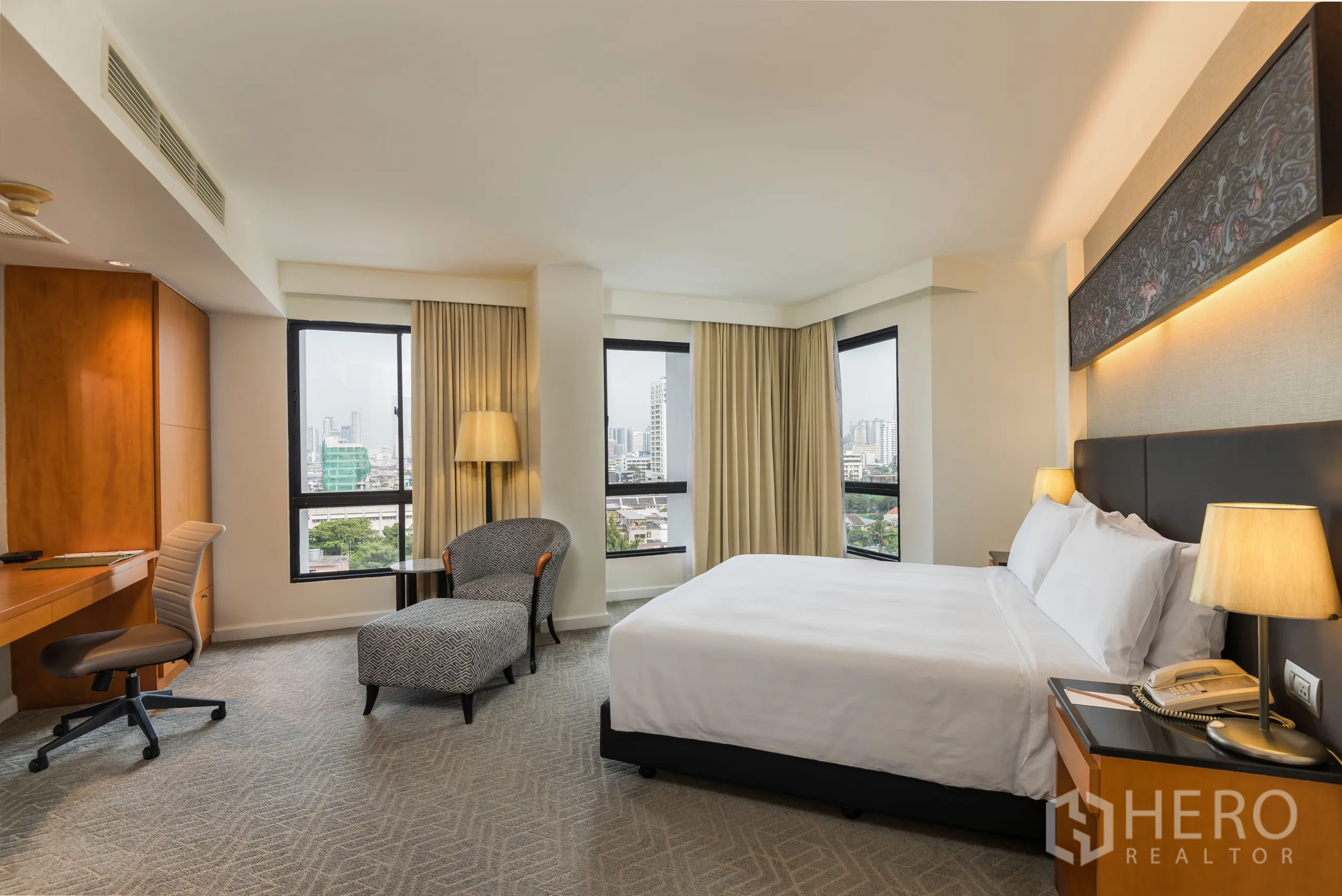 Condominium for rent in Yan Nawa, Bangkok - Corner master bedroom with work desk, chaise lounge and multiple windows framing skyline views.