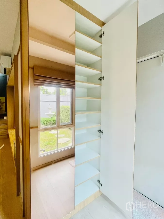 独立式住宅 出租在Prawet, Bangkok - 内置收纳柜与镜面门，园景窗旁的多层搁板