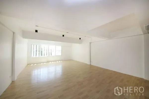 店屋 出租在Wang Thonglang, Bangkok - 宽敞多功能楼层，白墙、木纹地板与明亮窗户。