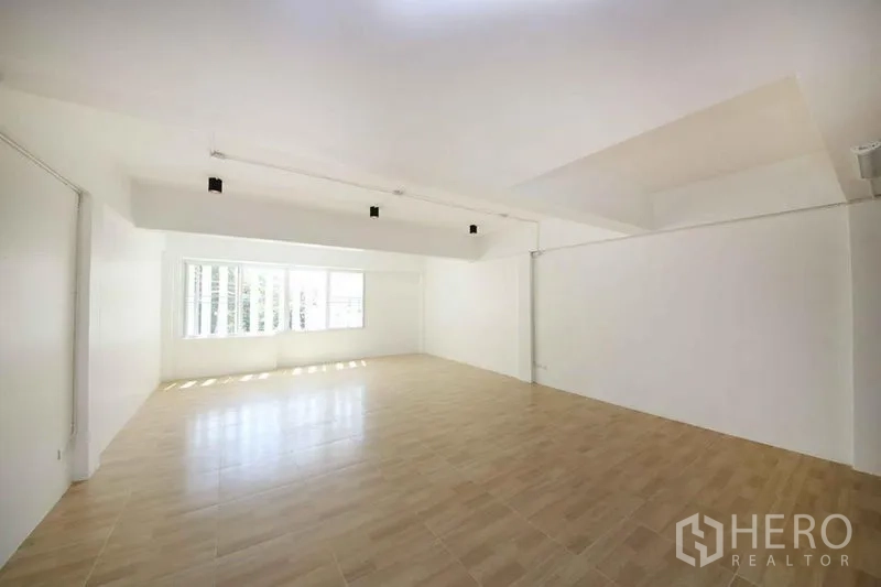 店屋 出租在Wang Thonglang, Bangkok - 宽敞多功能楼层，白墙、木纹地板与明亮窗户。