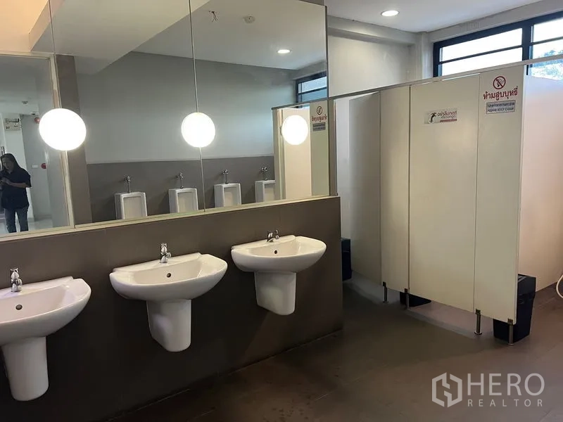 Office Space for rent in Mueang Samut Prakan, Samut Prakan - Shared restroom with sinks, large mirrors, cubicles, and urinals.