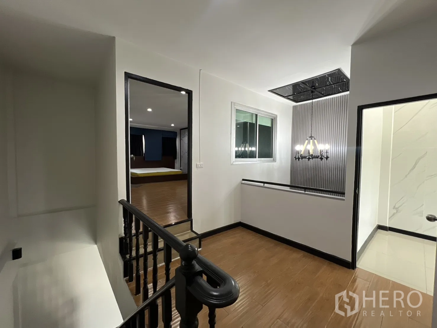 ทาวน์เฮาส์ for rent in Watthana, Bangkok - โถงบันไดพร้อมโคมไฟ พื้นไม้ มองเห็นทางเข้าห้องนอนและห้องน้ำ
