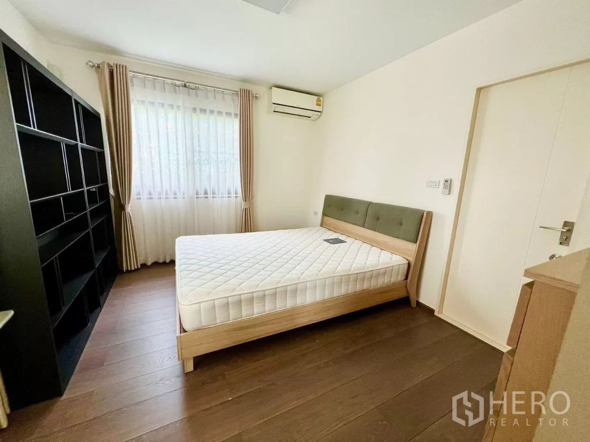 Detached House for rent or sale in Bang Phli, Samut Prakan - Guest bedroom with bed, shelving unit and window drapes.