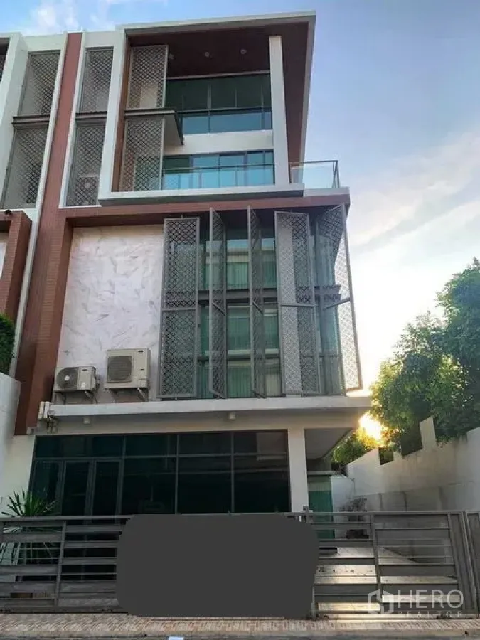 Townhouse for rent or sale in Yan Nawa, Bangkok - Modern multi-storey townhouse facade with large windows, balcony and gated driveway.