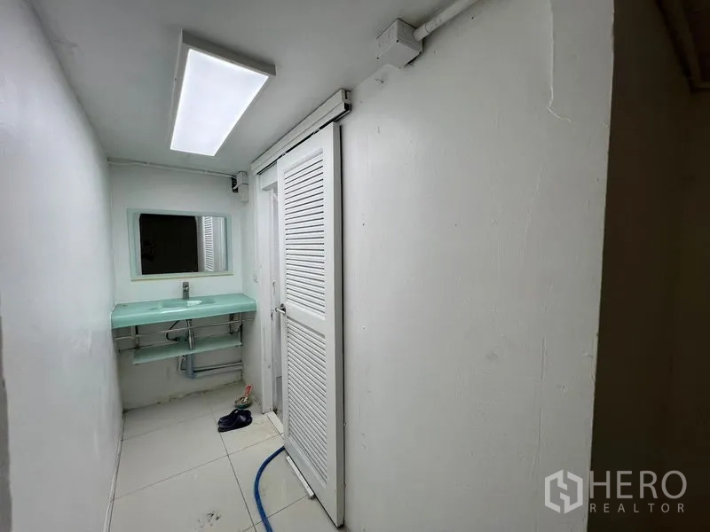 零售空间 出租在Khlong Toei, Bangkok - 紧凑卫生间区，推拉门与薄荷绿玻璃洗手台。