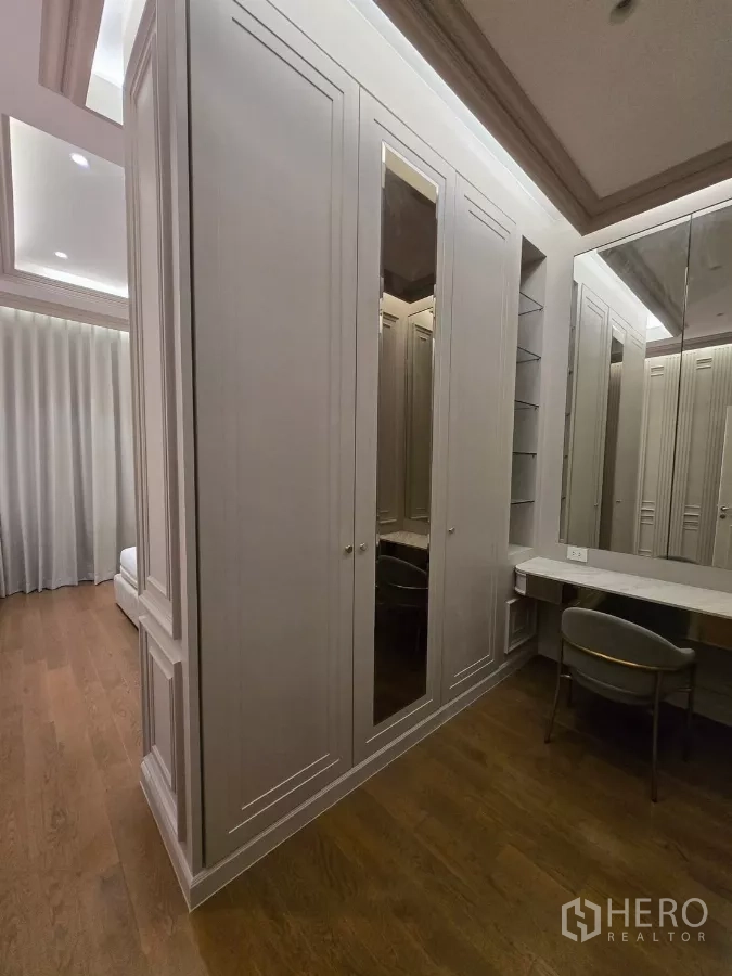 Detached House for rent or sale in Bang Kapi, Bangkok - Walk-in closet with extensive built-in wardrobes, vanity and wood flooring.