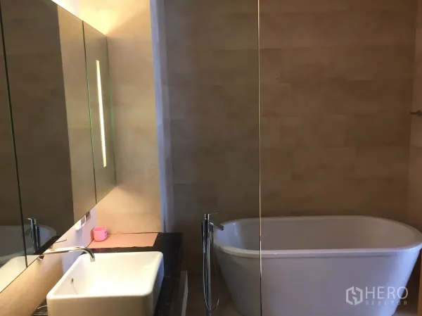 公寓 出租或出售在Bang Rak, Bangkok - 卫浴配独立浴缸、大镜面与方形洗手台。