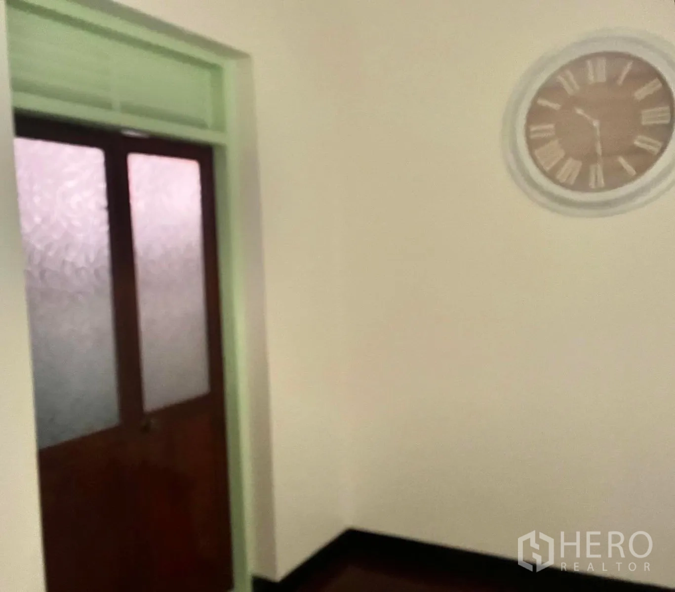 Shophouse for rent in Bang Rak, Bangkok - Hallway with frosted glass door and wall clock.