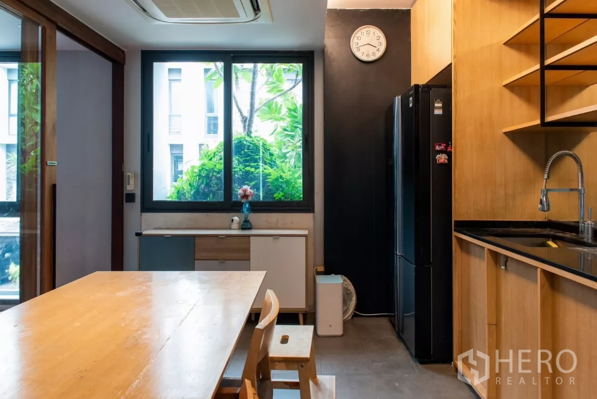 ทาวน์เฮาส์ ให้เช่าในLat Phrao, Bangkok - ครัวสว่างด้วยหน้าต่างบานใหญ่ ตู้เย็นสีดำและซิงก์