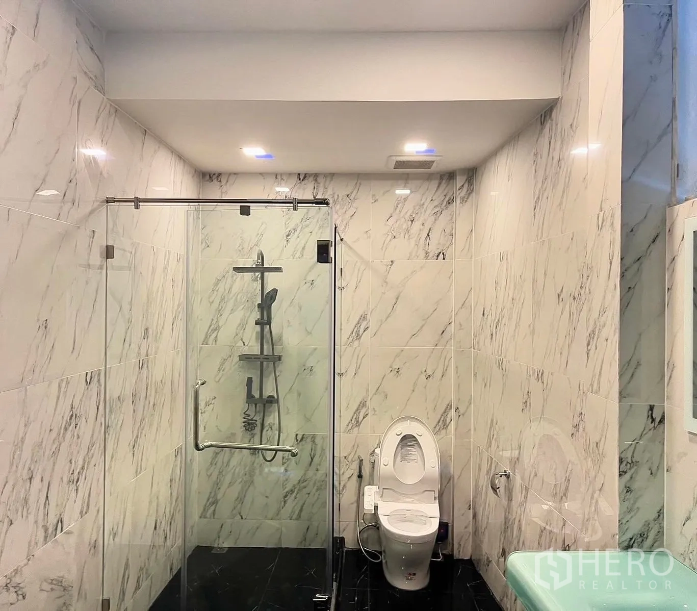 Shophouse for rent in Bang Rak, Bangkok - Spacious marble bathroom with glass shower enclosure and toilet.