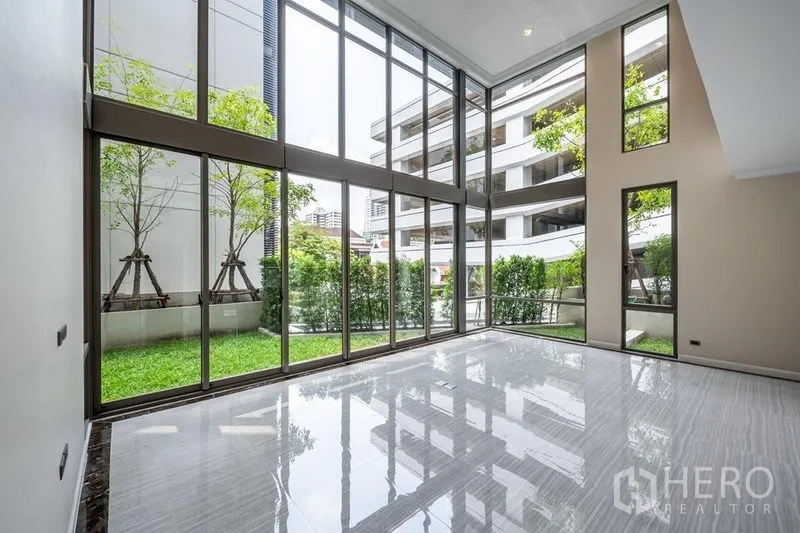 ทาวน์เฮาส์ ให้เช่าในKhlong Toei, Bangkok - ห้องนั่งเล่นเพดานสูง ผนังกระจกเต็มบาน เปิดสู่สวนส่วนตัว