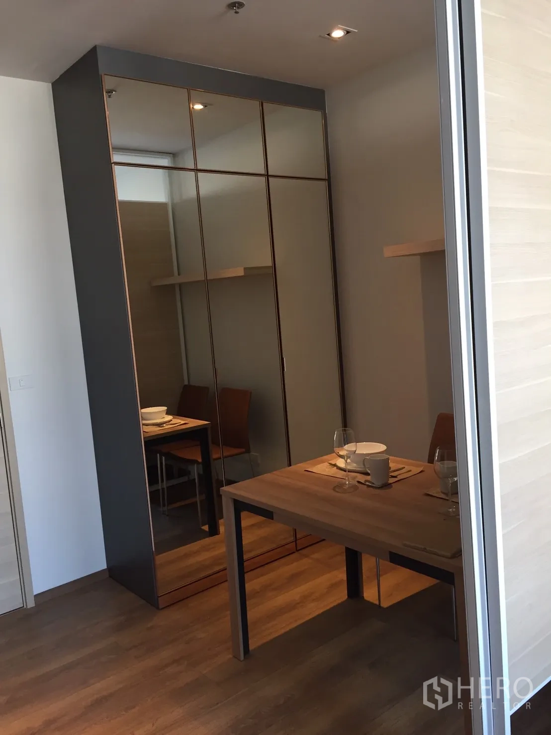 Condominium for rent or sale in Khlong Toei, Bangkok - Built-in mirrored closet next to a small dining table in a modern Bangkok condominium.