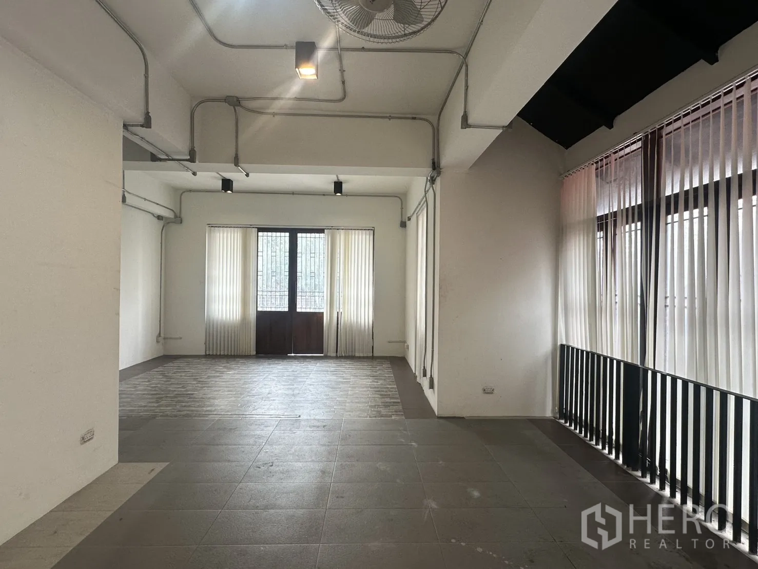 带办公室的家 for rent in Pathum Wan, Bangkok - 白色开放式楼层，大面积窗墙、百叶与吊扇，地面为瓷砖。