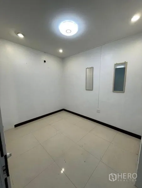 Shophouse for rent in Chatuchak, Bangkok - Small empty room with white walls, recessed lighting and two wall mirrors.