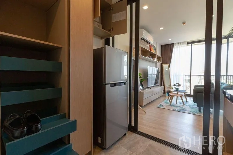 คอนโด ให้เช่าในWatthana, Bangkok - ครัวทางเข้า พร้อมตู้เย็นและประตูกระจกบานเลื่อนเชื่อมสู่ห้องนั่งเล่นสว่าง มีตู้เก็บรองเท้าบิวท์อิน