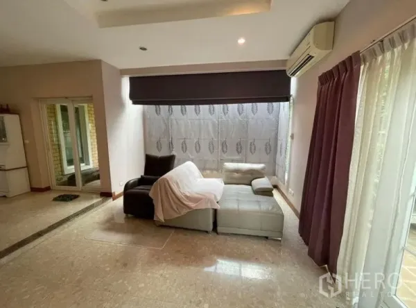 独立式住宅 出租 - 客厅一角配L型沙发，大窗与窗帘，连通推拉玻璃门。