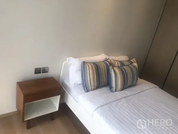 公寓 出租或出售在Khlong Toei, Bangkok - 温馨次卧，双人床、条纹抱枕与床头柜