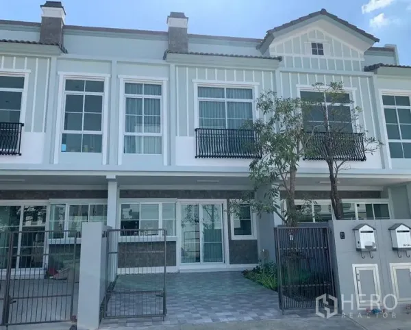 联排别墅 出租 - Indy 2 社区两层联排别墅外立面，带栅栏车位与阳台栏杆。