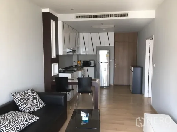 คอนโด ให้เช่าในBangkok - พื้นที่นั่งเล่นและครัวแบบโอเพ่นแปลน พร้อมเคาน์เตอร์ทานอาหาร เก้าอี้ และพื้นไม้ธรรมชาติ