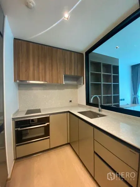 公寓 出租在Watthana, Bangkok - 现代L形厨房，石质台面，电磁炉、嵌入式烤箱与木质柜体