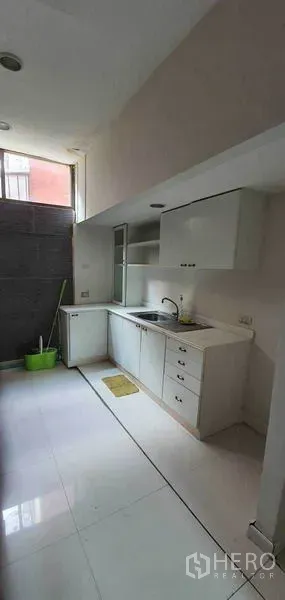 Home Office for rent in Watthana, Bangkok - Compact pantry kitchen with white cabinets, sink and a high window.