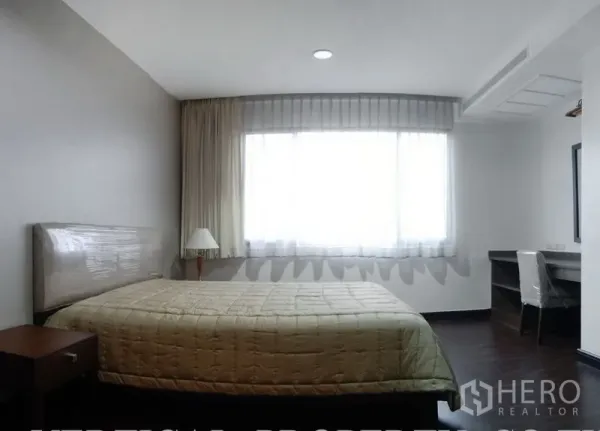 Condominium for rent in Watthana, Bangkok - Bedroom with large window, desk, and neutral decor.