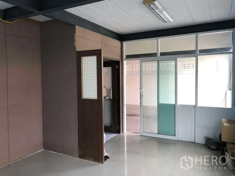 คลังสินค้า ให้เช่าในPak Kret, Nonthaburi - ห้องสำนักงานชั้นล่างภายในโกดัง ประตูกระจกบานเลื่อน พื้นกระเบื้อง และผนังกั้น