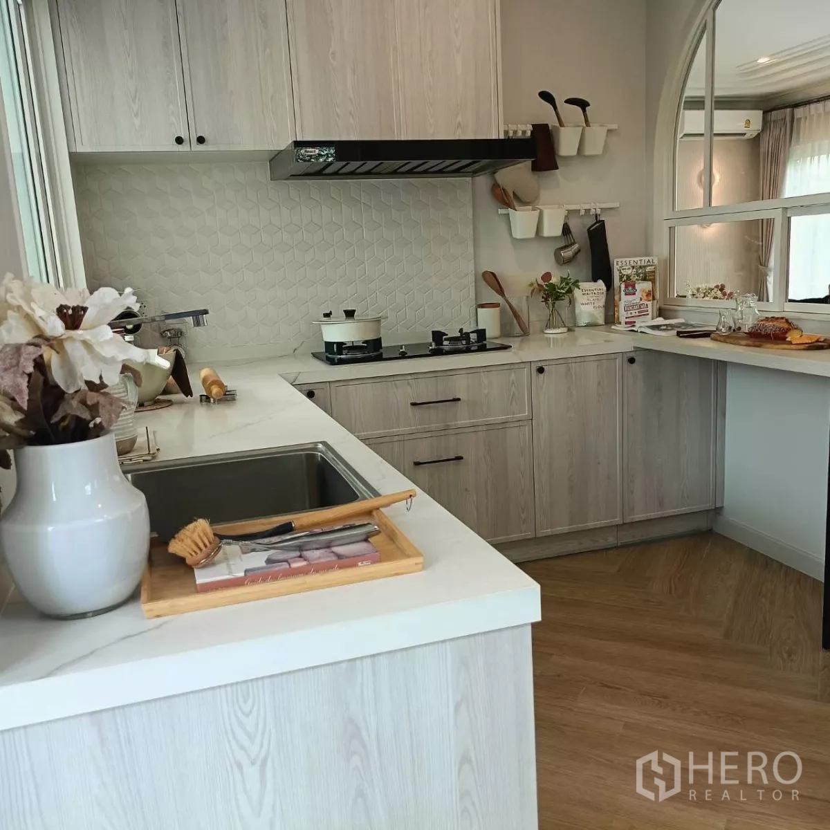 Detached House for rent in Bang Phli, Samut Prakan - Light wood U-shaped kitchen with gas hob, hood and white countertops.