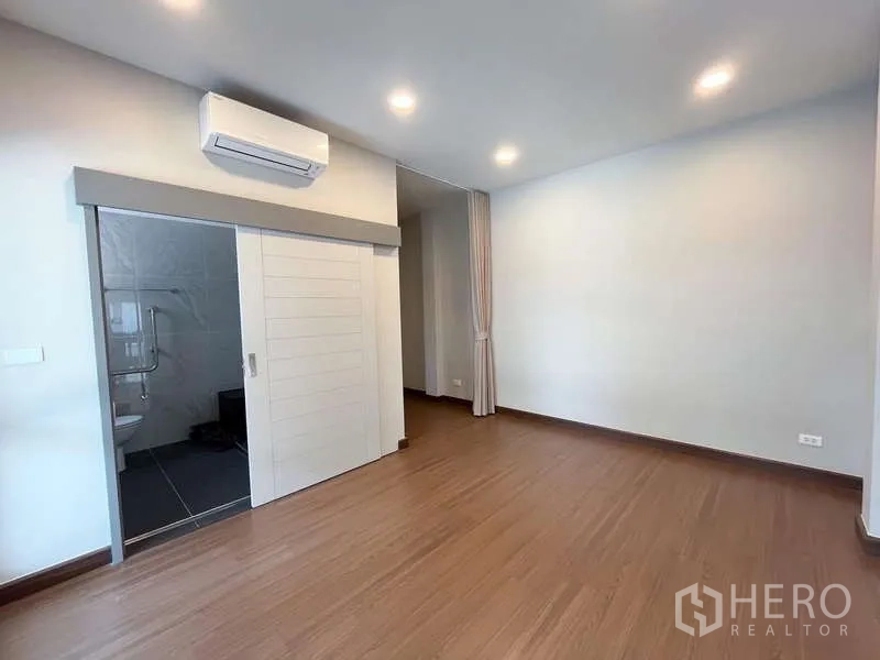Detached House for rent or sale in Bang Phli, Samut Prakan - Multipurpose room with wood flooring and sliding door to an ensuite bathroom.